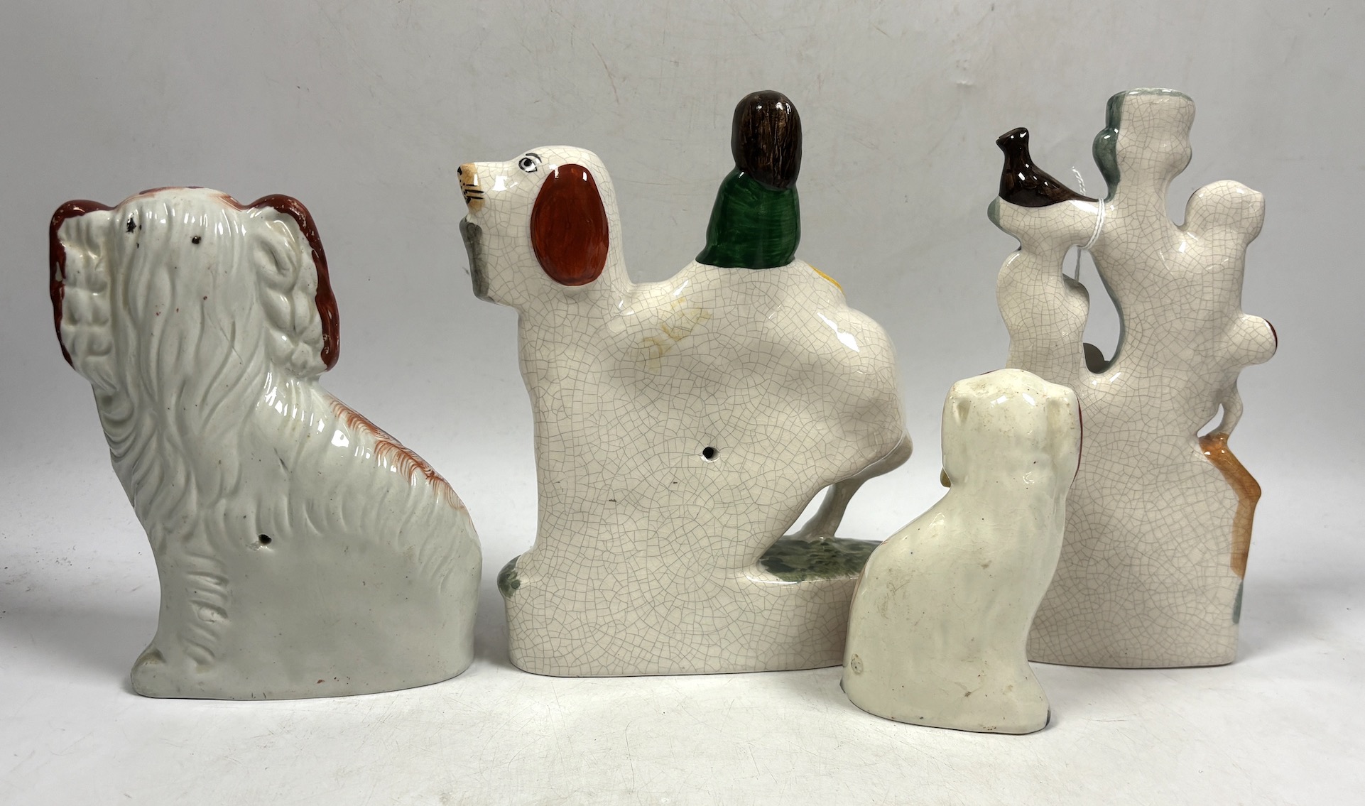 Two Staffordshire spaniels and two pottery groups, largest 19cm high